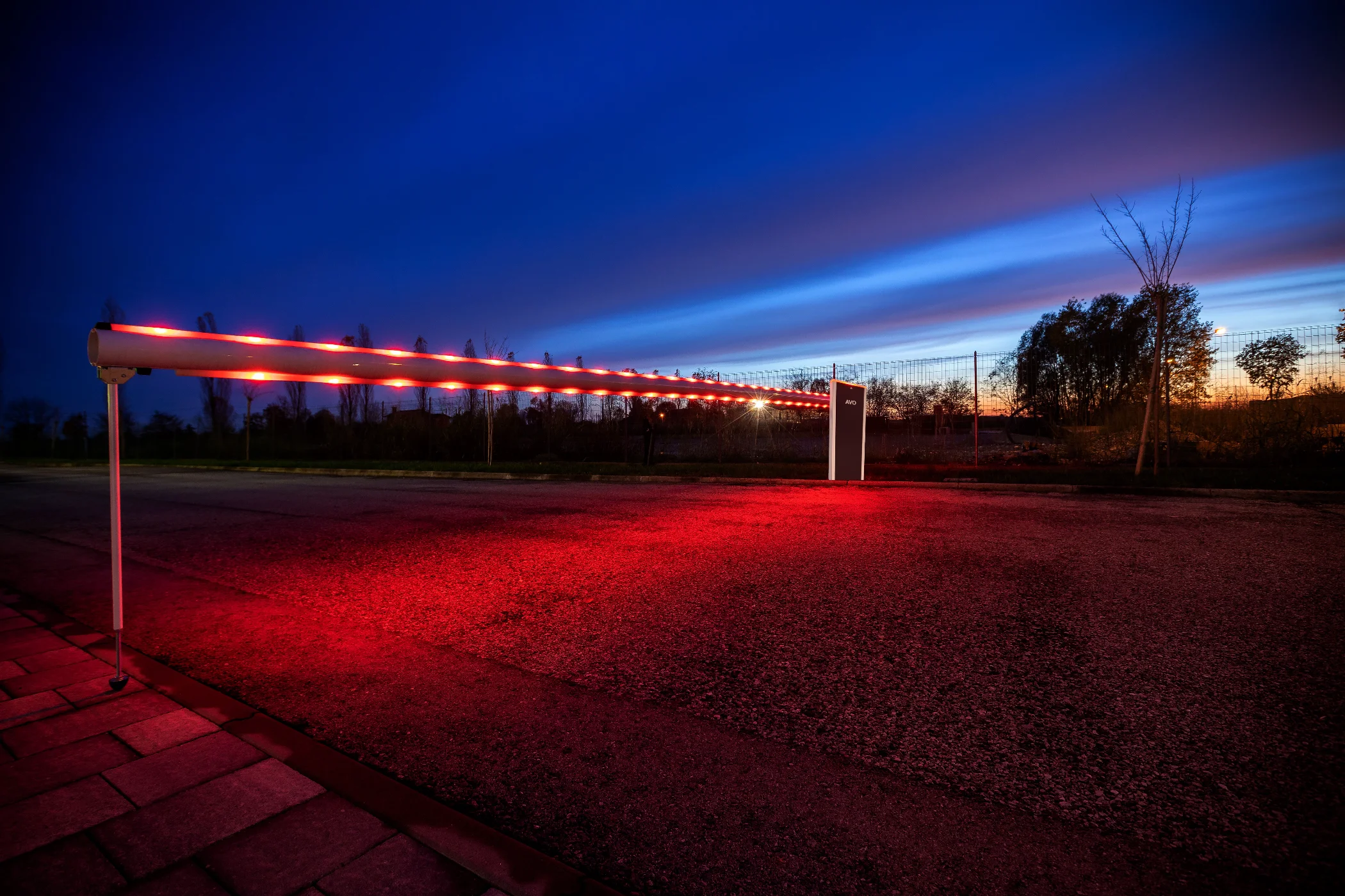 Automatischer Torantrieb als Schranke mit roter LED-Beleuchtung im Dämmerlicht