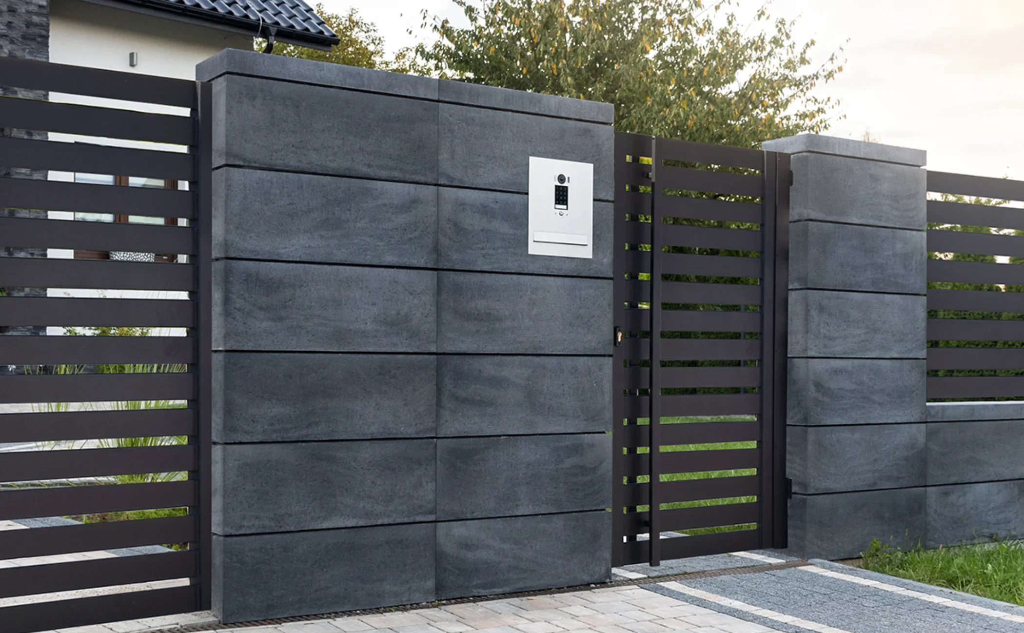 Moderner Lamellenzaun mit Zugangstor, Betonsäulen und integriertem Briefkasten